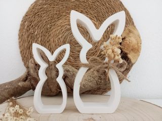 Zwei Hasen Silhouetten vor einem Seil aus Naturmaterialien