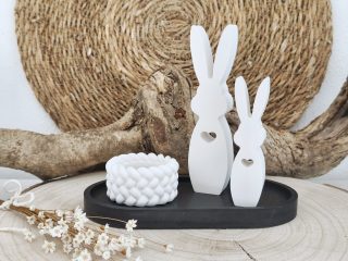 Dekorative weiße Hasenfiguren auf rustikaler Holzplatte mit Trockenblumen - Osterdeko Teelichthalter Set handgemacht