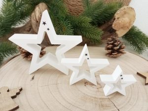Drei weiße Sternfiguren aus Holz auf Baumstammscheibe mit Tannenzapfen - Weihnachtssterne Dekoration handgefertigt